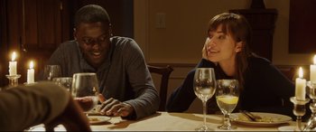 Movie still from “Get Out” (2017), directed by Jordan Peele – A man and a woman sitting at a dinner table; Medium shot, Over the shoulder angle