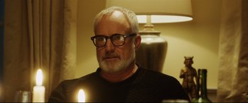 Movie still from “Get Out” (2017), directed by Jordan Peele – An older man wearing glasses and a black shirt; Close Up shot, Over the shoulder angle