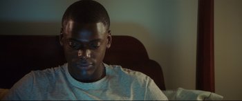Movie still from “Get Out” (2017), directed by Jordan Peele – A man sitting in front of a computer screen; Close Up shot, High angle
