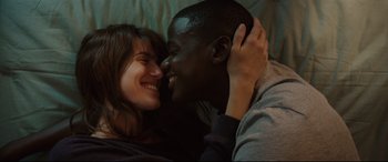 Movie still from “Get Out” (2017), directed by Jordan Peele – A man and a woman are laying in a bed together; Close Up shot, Overhead angle