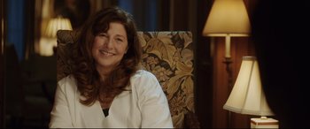 Movie still from “Get Out” (2017), directed by Jordan Peele – A woman sitting in a chair smiling for the camera; Close Up shot, Over the shoulder angle