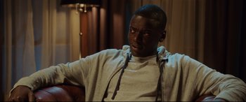 Movie still from “Get Out” (2017), directed by Jordan Peele – A man sitting in front of a window with his eyes wide open; Close Up shot, Over the shoulder angle
