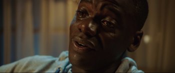 Movie still from “Get Out” (2017), directed by Jordan Peele – A person with tears in his eyes; Close Up shot, High angle