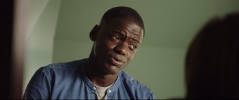 Movie still from “Get Out” (2017), directed by Jordan Peele – A person wearing a blue shirt; Close Up shot, Over the shoulder angle