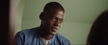 Movie still from “Get Out” (2017), directed by Jordan Peele – A person wearing a blue shirt; Close Up shot, Over the shoulder angle