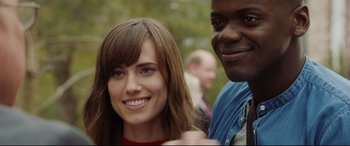 Movie still from “Get Out” (2017), directed by Jordan Peele – A woman and a man smile for the camera; Close Up shot, Over the shoulder angle