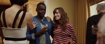 Movie still from “Get Out” (2017), directed by Jordan Peele – A man and a woman posing for a picture; Medium shot, Over the shoulder angle
