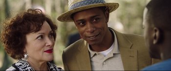 Movie still from “Get Out” (2017), directed by Jordan Peele – A person wearing a hat and a jacket; Close Up shot, Over the shoulder angle