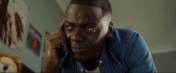 Movie still from “Get Out” (2017), directed by Jordan Peele – A person talking on a cell phone; Close Up shot, High angle