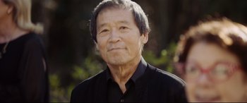 Movie still from “Get Out” (2017), directed by Jordan Peele – An older man wearing a black shirt with trees in the background; Close Up shot, Low angle