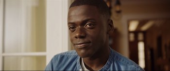 Movie still from “Get Out” (2017), directed by Jordan Peele – A person wearing a blue shirt; Close Up shot, Over the shoulder angle