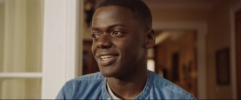 Movie still from “Get Out” (2017), directed by Jordan Peele – A person smiling; Close Up shot, Over the shoulder angle