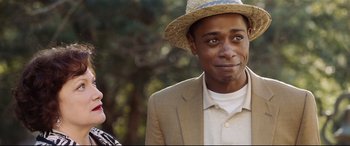 Movie still from “Get Out” (2017), directed by Jordan Peele – A man wearing a straw hat and a suit; Close Up shot, Over the shoulder angle
