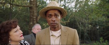 Movie still from “Get Out” (2017), directed by Jordan Peele – A man in a tan suit and a straw hat; Close Up shot, Over the shoulder angle
