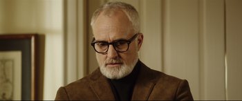 Movie still from “Get Out” (2017), directed by Jordan Peele – An older man with a beard wearing glasses and a brown jacket; Close Up shot, Low angle