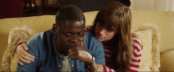 Movie still from “Get Out” (2017), directed by Jordan Peele – A man and a woman sitting next to each other on a couch; Close Up shot, Over the shoulder angle