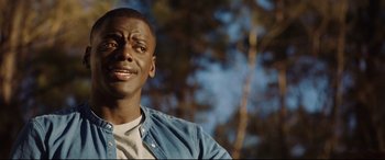 Movie still from “Get Out” (2017), directed by Jordan Peele – A person wearing a jean jacket; Close Up shot, Over the shoulder angle