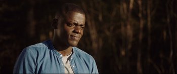 Movie still from “Get Out” (2017), directed by Jordan Peele – A person wearing a blue shirt; Close Up shot, Over the shoulder angle
