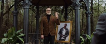 Movie still from “Get Out” (2017), directed by Jordan Peele – An older man standing next to a picture of himself; Medium shot, Over the shoulder angle