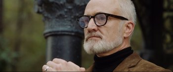 Movie still from “Get Out” (2017), directed by Jordan Peele – An older man with a beard wearing glasses; Close Up shot, Low angle