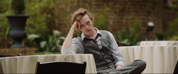 Movie still from “Get Out” (2017), directed by Jordan Peele – A man sitting on a chair with his hand on his head; Medium shot, Over the shoulder angle