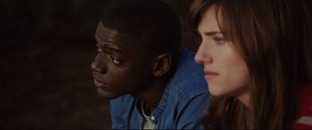 Movie still from “Get Out” (2017), directed by Jordan Peele – A man and a woman sitting next to each other; Close Up shot, Over the shoulder angle