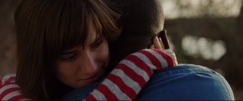 Movie still from “Get Out” (2017), directed by Jordan Peele – A woman is hugging a man in a striped sweater; Close Up shot, Over the shoulder angle