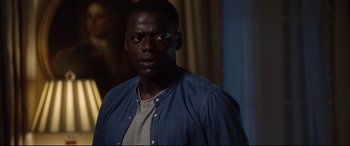 Movie still from “Get Out” (2017), directed by Jordan Peele – A person wearing a blue shirt; Close Up shot, Over the shoulder angle
