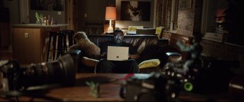 Movie still from “Get Out” (2017), directed by Jordan Peele – A man sitting on top of a brown leather couch; Medium shot, High angle