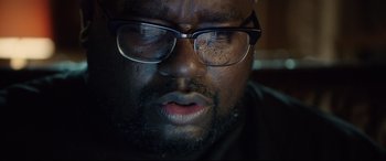 Movie still from “Get Out” (2017), directed by Jordan Peele – A person wearing glasses; Close Up shot, Low angle