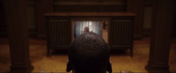 Movie still from “Get Out” (2017), directed by Jordan Peele – A man sitting in front of a television; Extreme Close Up shot, Over the shoulder angle