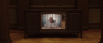 Movie still from “Get Out” (2017), directed by Jordan Peele – An old tv with a man in a hospital gown on it; Wide shot, Overhead angle