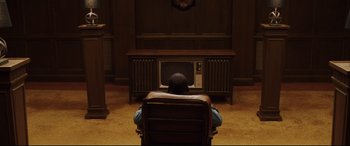 Movie still from “Get Out” (2017), directed by Jordan Peele – A person sitting in a chair watching a television; Medium shot, High angle