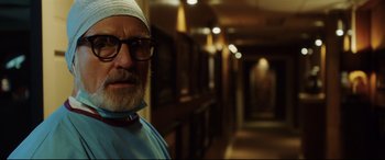 Movie still from “Get Out” (2017), directed by Jordan Peele – A man with a beard wearing a surgical cap and glasses; Close Up shot, Low angle