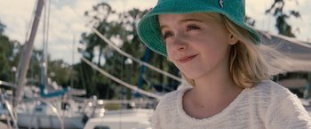 Movie still from “Gifted” (2017), directed by Marc Webb – A young girl wearing a blue hat and a white sweater; Close Up shot, Over the shoulder angle