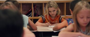 Movie still from “Gifted” (2017), directed by Marc Webb – A young girl sitting at a table writing on paper; Close Up shot, Over the shoulder angle
