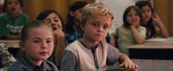 Movie still from “Gifted” (2017), directed by Marc Webb – A young boy sitting in front of other children; Close Up shot, Over the shoulder angle