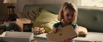 Movie still from “Gifted” (2017), directed by Marc Webb – A little girl holding an apple laptop; Close Up shot, Over the shoulder angle