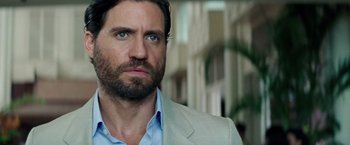 Movie still from “Gold” (2016), directed by Stephen Gaghan – A person wearing a suit and tie; Close Up shot, Over the shoulder angle