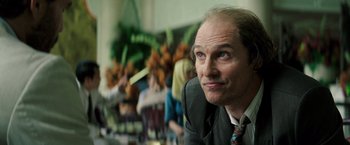 Movie still from “Gold” (2016), directed by Stephen Gaghan – A person wearing a suit and tie; Close Up shot, Low angle