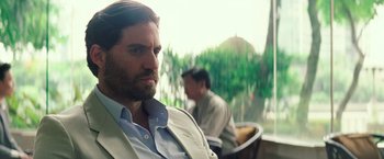 Movie still from “Gold” (2016), directed by Stephen Gaghan – A person wearing a suit and tie; Close Up shot, Over the shoulder angle
