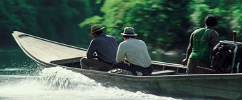 Movie still from “Gold” (2016), directed by Stephen Gaghan – Two men sitting in a boat on a river; Wide shot, High angle