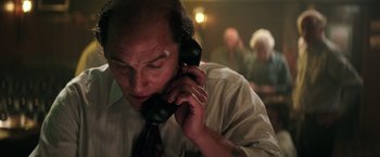 Movie still from “Gold” (2016), directed by Stephen Gaghan – A man talking on a phone while wearing a tie; Close Up shot, Low angle