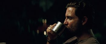 Movie still from “Gold” (2016), directed by Stephen Gaghan – A person drinking from a cup; Close Up shot, Over the shoulder angle