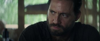 Movie still from “Gold” (2016), directed by Stephen Gaghan – A person with a beard looking to his left; Close Up shot, Over the shoulder angle