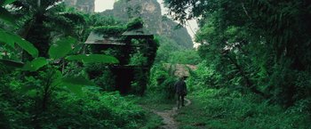 Movie still from “Gold” (2016), directed by Stephen Gaghan – A man walking down a path in the middle of a forest; Extreme Wide shot, High angle