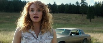 Movie still from “Gold” (2016), directed by Stephen Gaghan – A woman standing in front of a car in a field; Close Up shot, Low angle
