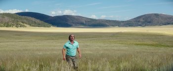 Movie still from “Gold” (2016), directed by Stephen Gaghan – A man standing in the middle of an open field; Wide shot, Low angle