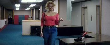 Movie still from “Gold” (2016), directed by Stephen Gaghan – A woman in a pink shirt and blue jeans is pointing; Medium shot, Low angle