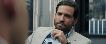 Movie still from “Gold” (2016), directed by Stephen Gaghan – A person wearing a suit and tie; Close Up shot, Over the shoulder angle